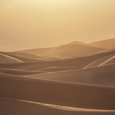 the sun is shining over the sand dunes