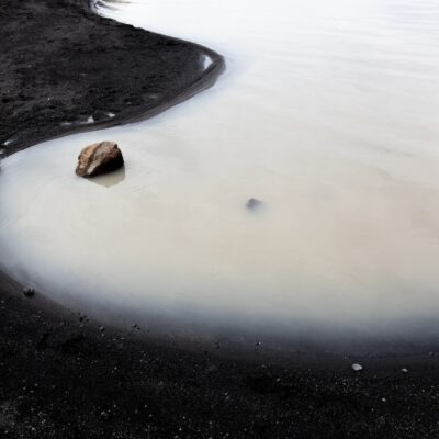 a rock sitting in the middle of a body of water
