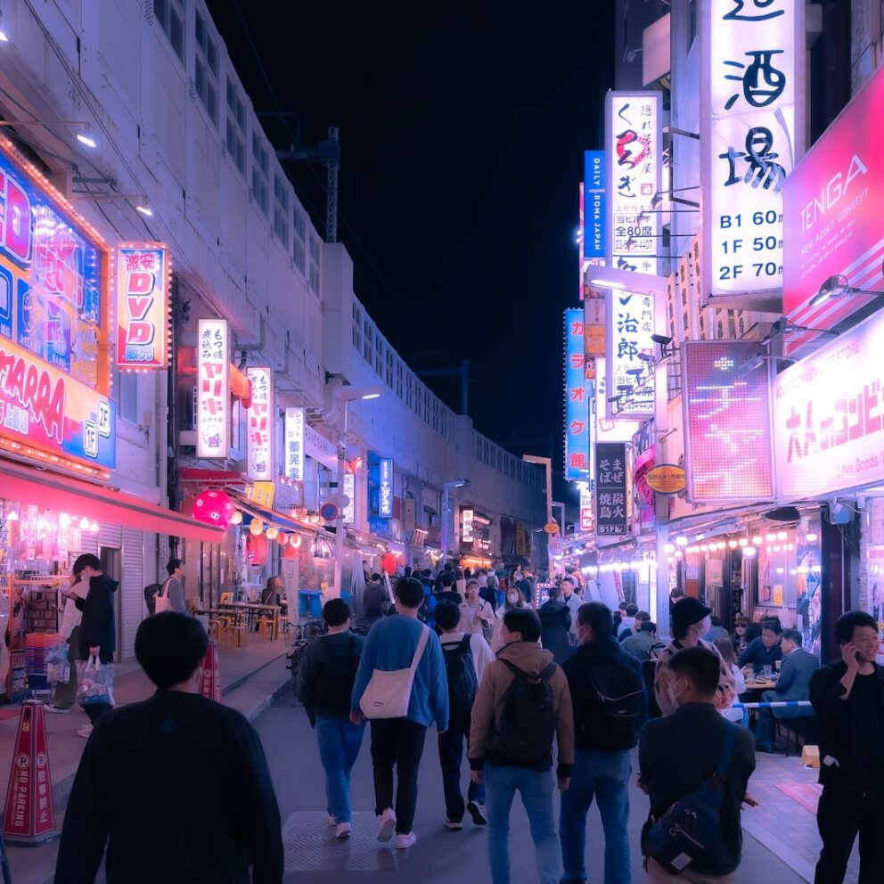 a group of people walking down a street at night