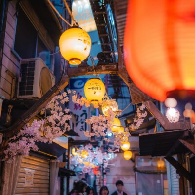 a group of people walking down a street next to tall buildings